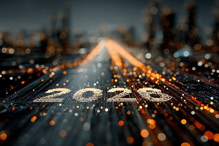 Futuristische, unscharfe Stadt-Skyline bei Nacht mit Bokeh-Lichtern. Im Vordergrund verlaufen digitale gold-orange Lichtpunkte. Auf der Fläche steht 2025, dargestellt aus vielen glitzernden Lichtpunkten