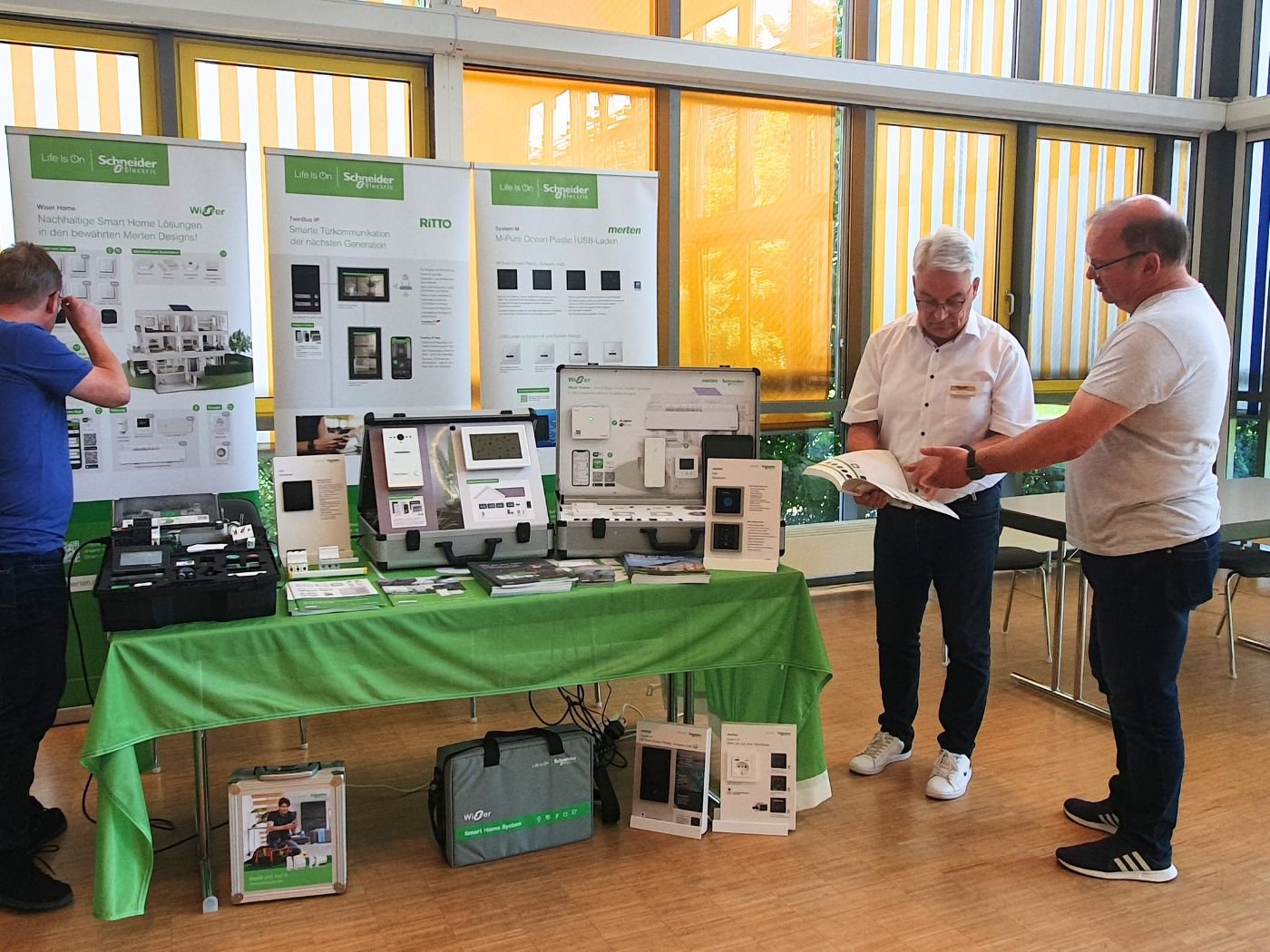 Bild zeigt einen Aussteller-Stand im Rahmen der Fachschulungstage 2024 in Glauchau. Ein Mitarbeiter ist mit einem Besucher in ein Gespräch vertieft.