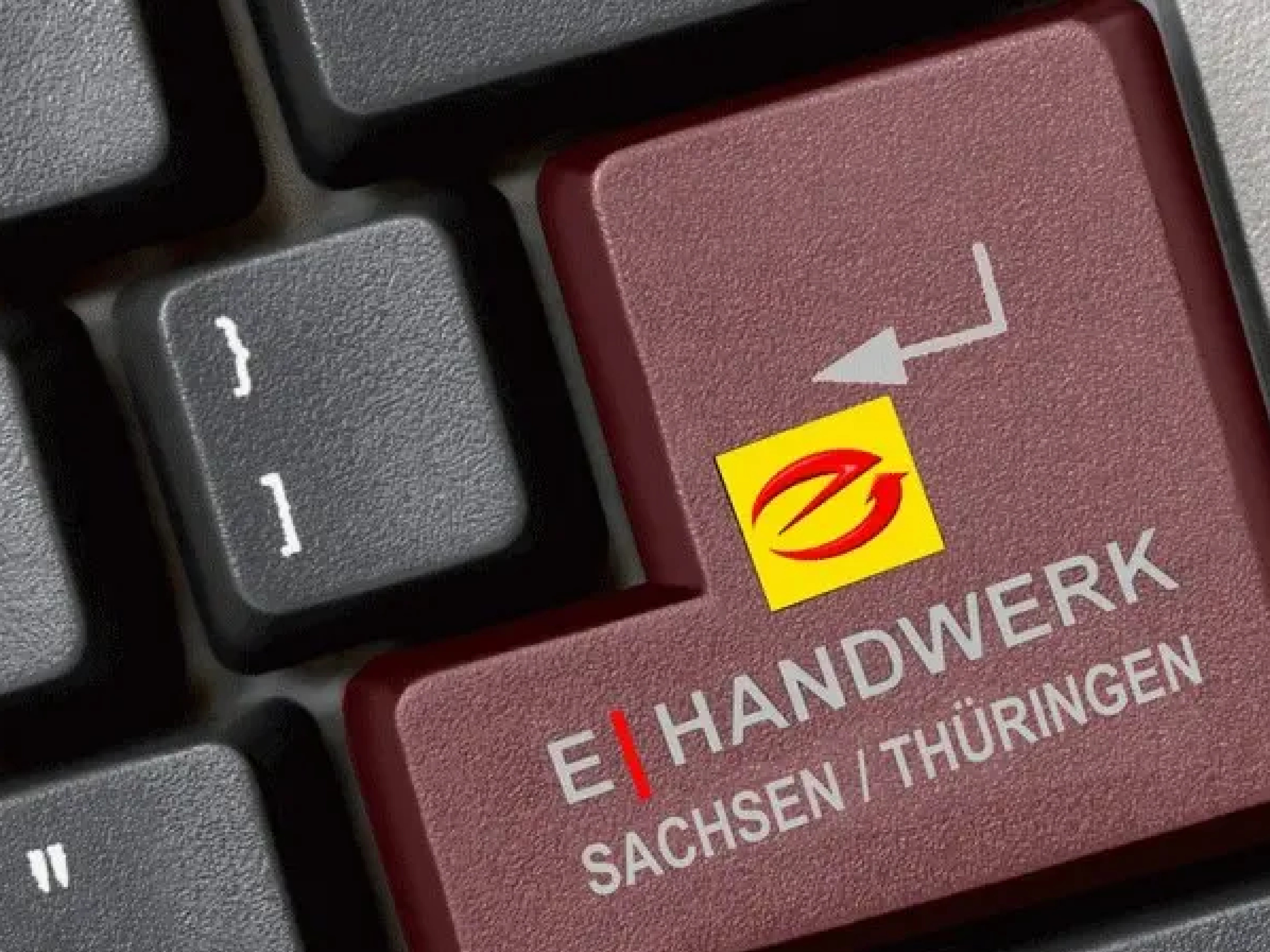 Tastatur mit roter Enter-Taste, darauf ist ein gelbes Quadrat mit rotem stilisiertem E und der Aufschrift "E-Handwerk Sachsen/Thüringen"