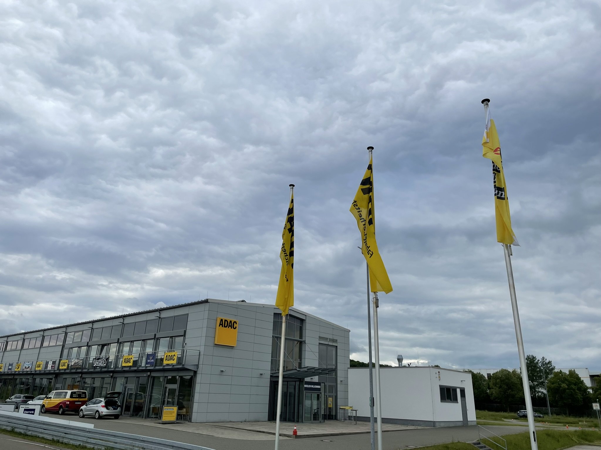 Foto zeigt den Eingangsbereich des Veranstaltungsorte für die Fachschulungstage 2024 in Nohra/Weimar. Vor der Gebäude befinden sich drei Fahnen.